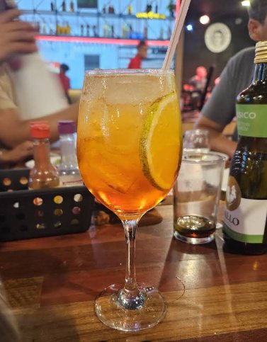 Drink cítrico servido na taça com rodela de laranja